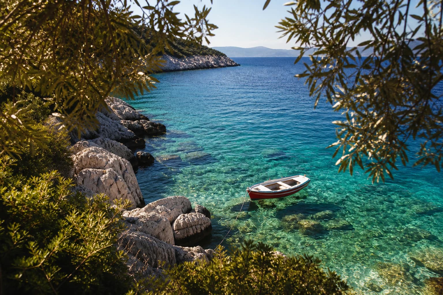 Kaş yakınlarında kayalık kıyıya bağlanmış küçük teknenin bulunduğu berrak koy